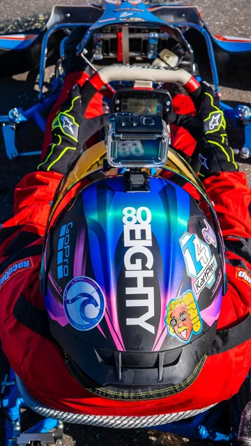 Iridescent racing helmet resting on a kart
