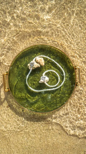Pearl bracelet in a shell on wet sand